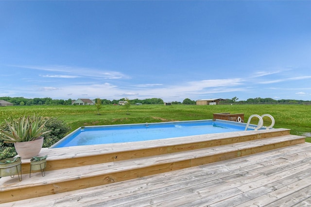 view of pool with a rural view and a lawn