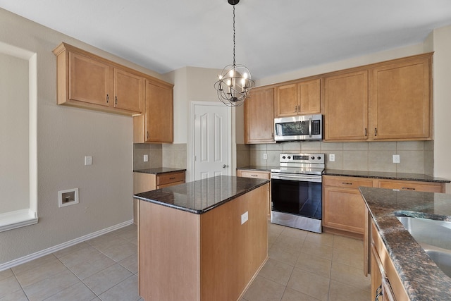 kitchen featuring hanging light fixtures, an inviting chandelier, decorative backsplash, a kitchen island, and appliances with stainless steel finishes