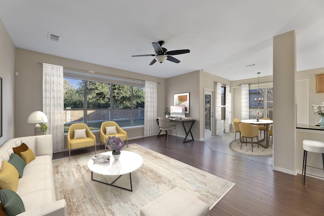 living room featuring dark hardwood / wood-style floors and ceiling fan with notable chandelier