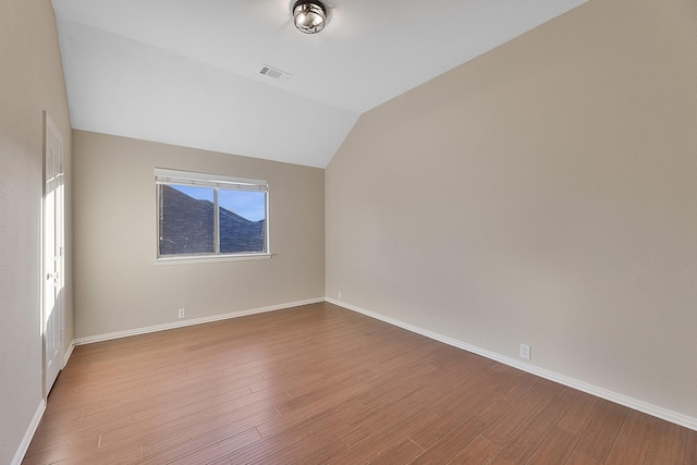 empty room featuring lofted ceiling and light wood-type flooring