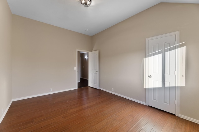 unfurnished room with vaulted ceiling and hardwood / wood-style flooring