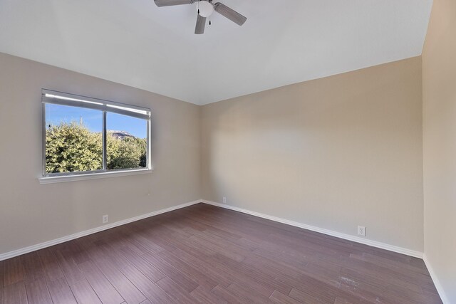 spare room with dark hardwood / wood-style floors and ceiling fan