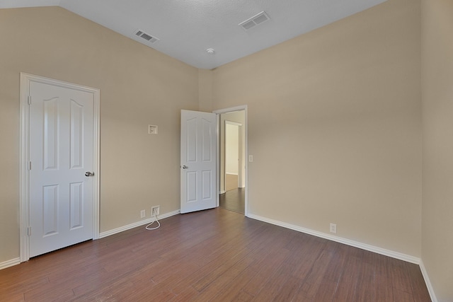 unfurnished bedroom featuring hardwood / wood-style flooring, a textured ceiling, and high vaulted ceiling