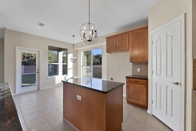 kitchen with tasteful backsplash, light tile patterned flooring, decorative light fixtures, and an inviting chandelier