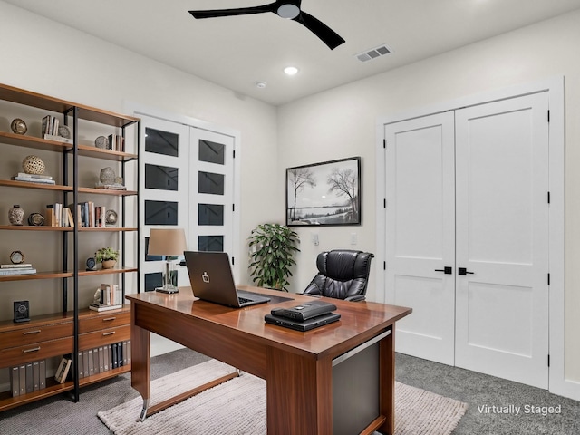 carpeted office space featuring ceiling fan