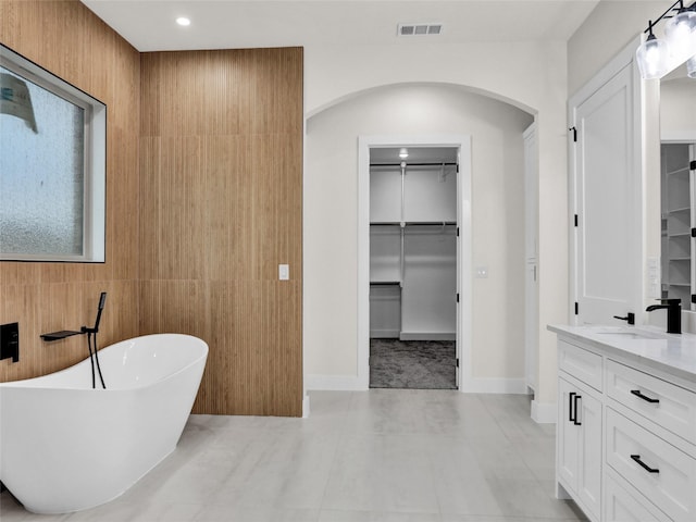 bathroom featuring a tub, tile patterned flooring, and vanity