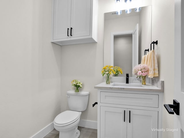 bathroom with vanity, toilet, and wood-type flooring