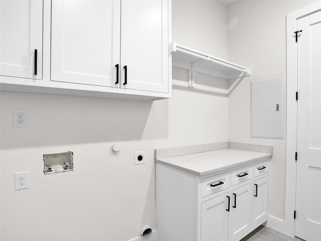 washroom featuring washer hookup, electric dryer hookup, cabinets, and light hardwood / wood-style flooring