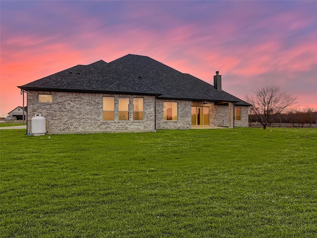 back house at dusk with a yard