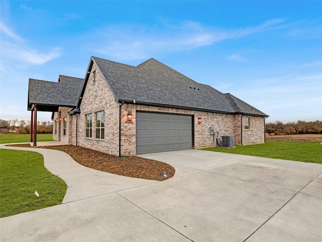 view of side of property with a yard, central AC unit, and a garage