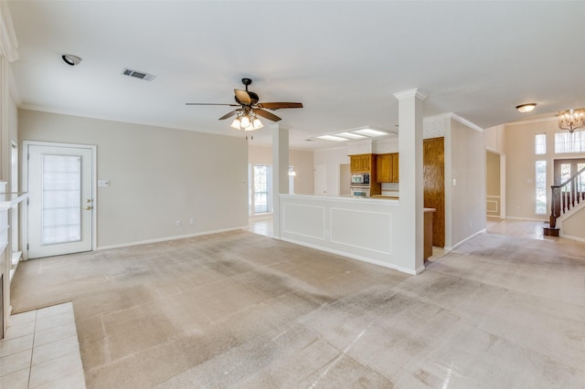 unfurnished living room featuring light carpet, crown molding, and ceiling fan with notable chandelier