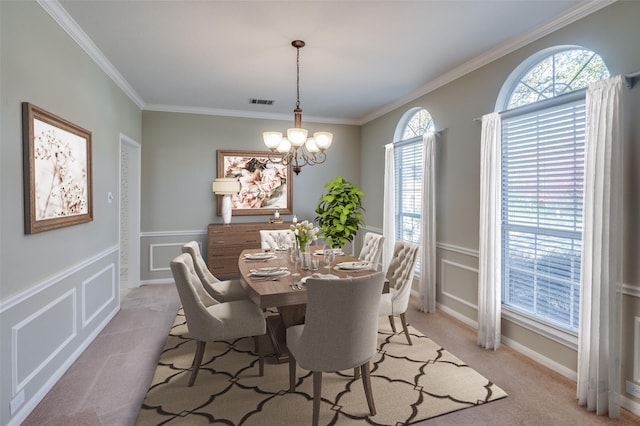 dining space with light colored carpet, crown molding, and a chandelier