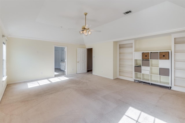 spare room featuring light carpet, built in features, ceiling fan, and a tray ceiling