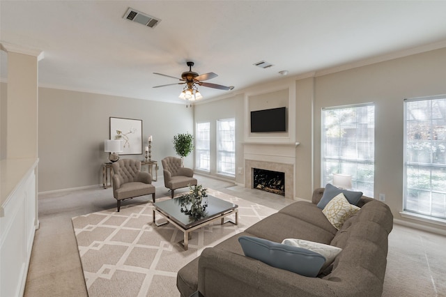 living room with crown molding, light colored carpet, and ceiling fan