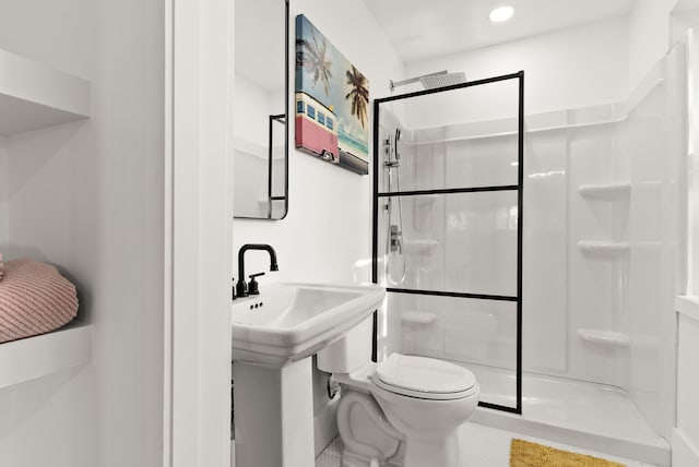 bathroom with tile patterned floors, toilet, and a shower with shower door