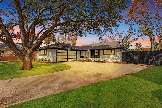 ranch-style home featuring a yard and a garage