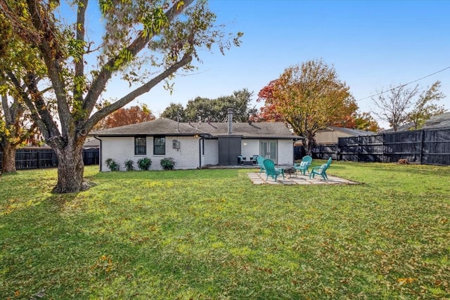 back of property with a lawn, a fire pit, and a patio