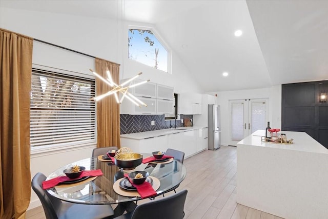 kitchen featuring decorative backsplash, sink, high vaulted ceiling, light hardwood / wood-style flooring, and white cabinets