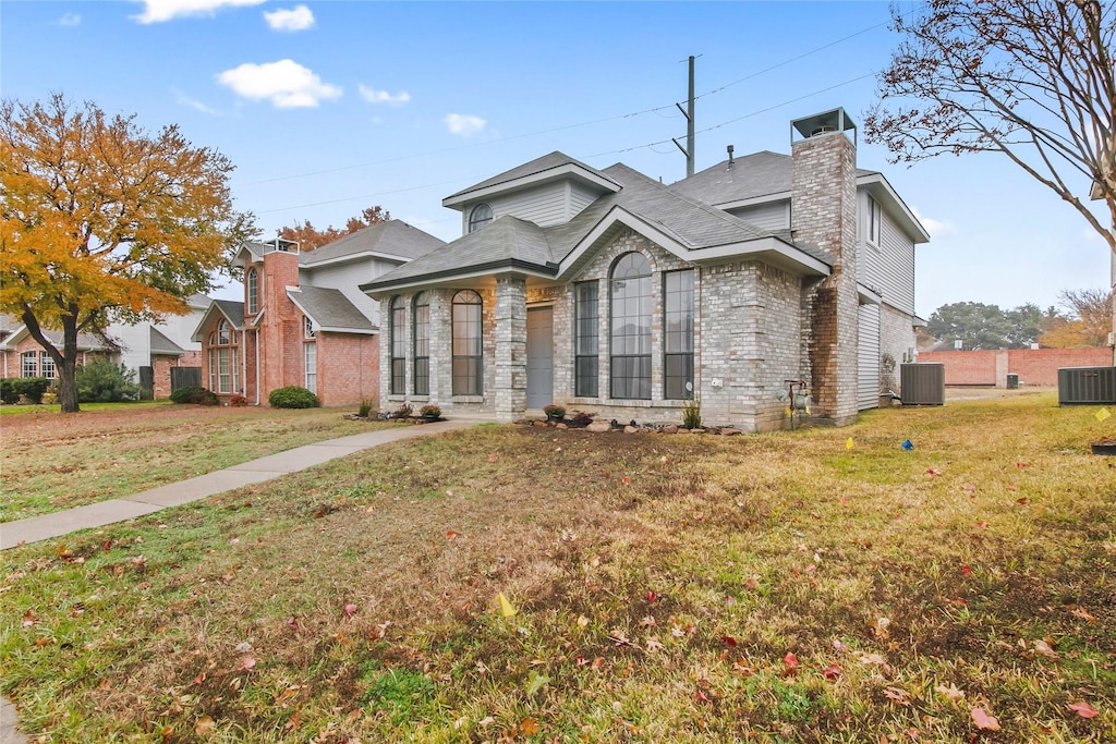 view of front of house with central AC unit and a front yard