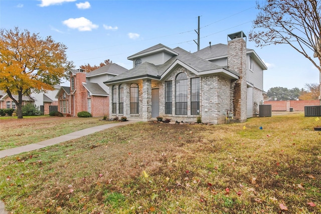 view of front of house with central AC unit and a front yard