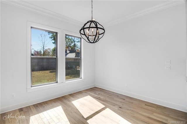 unfurnished dining area with plenty of natural light, light wood-type flooring, and crown molding