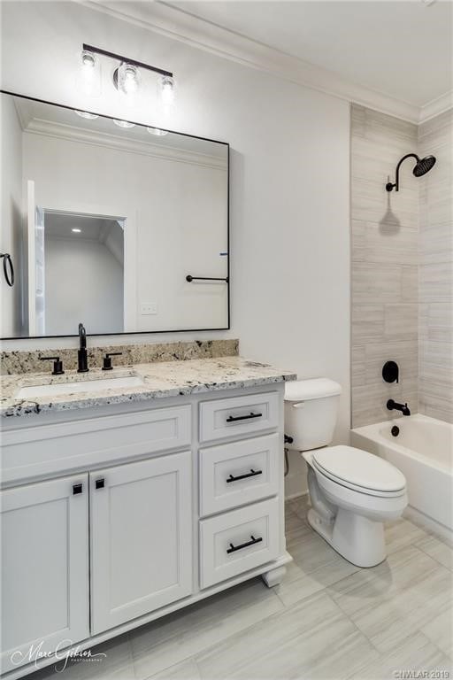 full bathroom with vanity, toilet, tiled shower / bath, and ornamental molding