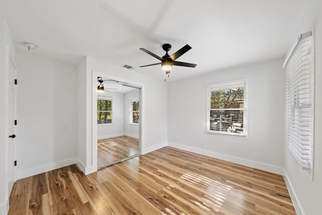 unfurnished room featuring ceiling fan, a healthy amount of sunlight, and light wood-type flooring