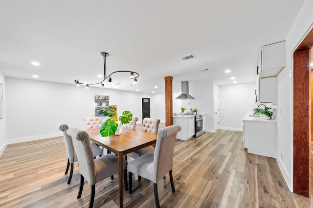 dining room featuring sink and light hardwood / wood-style floors