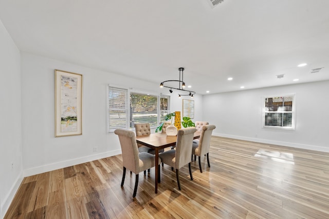 dining area featuring a notable chandelier and light wood-type flooring