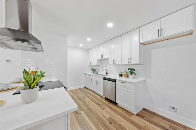 kitchen with light wood-type flooring, wall chimney exhaust hood, sink, dishwasher, and white cabinetry