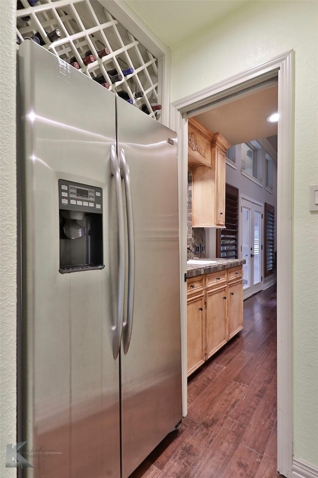 kitchen featuring stainless steel fridge, dark hardwood / wood-style flooring, and light brown cabinetry