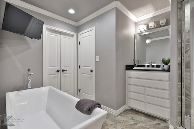 bathroom with a bathing tub, vanity, and ornamental molding