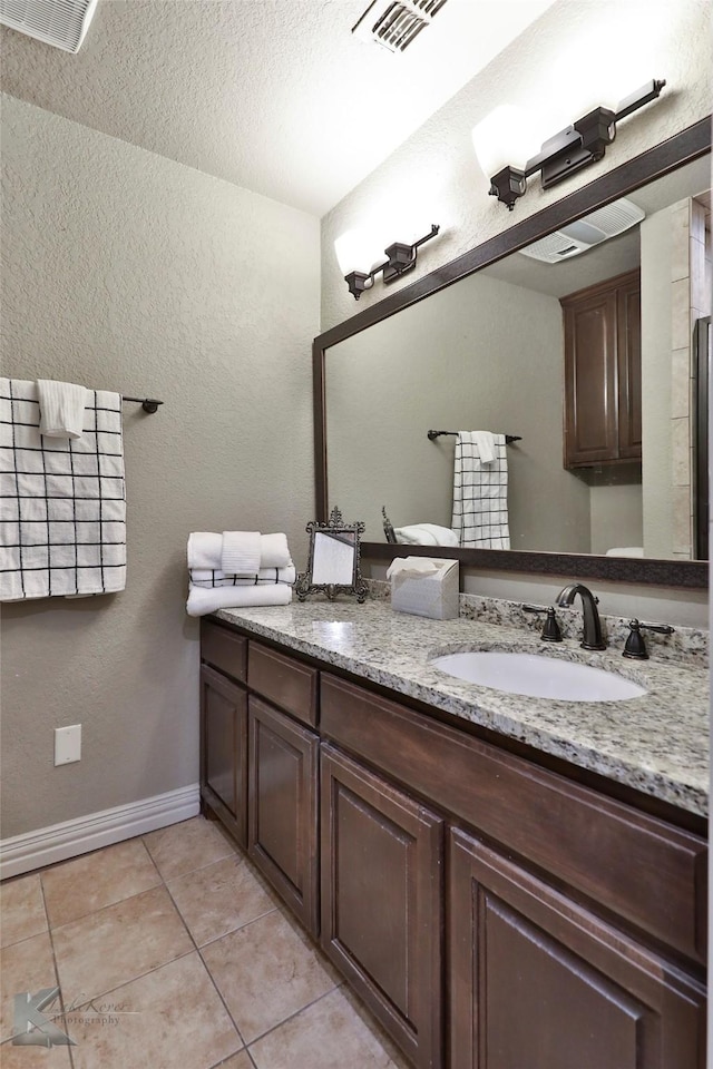 bathroom featuring tile patterned flooring, vanity, and a textured ceiling