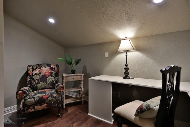 living area featuring a textured ceiling, dark wood-type flooring, and vaulted ceiling