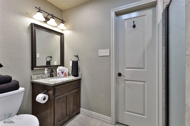 bathroom featuring tile patterned flooring, vanity, and toilet