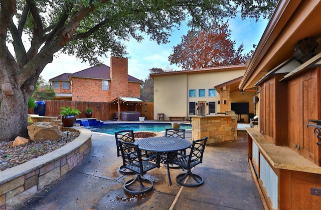 view of patio / terrace featuring an outdoor kitchen and a swimming pool with hot tub