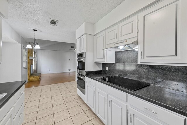 kitchen featuring white cabinetry, black electric stovetop, light tile patterned floors, and hanging light fixtures