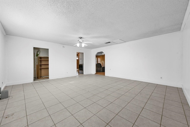 tiled empty room featuring a textured ceiling and ceiling fan