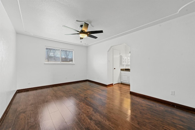 spare room with a textured ceiling, dark hardwood / wood-style floors, and ceiling fan