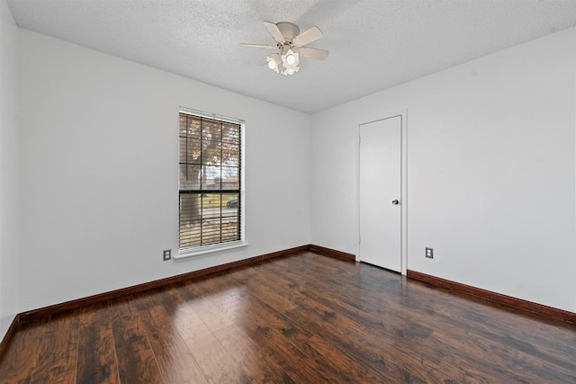 spare room with a textured ceiling, ceiling fan, and dark wood-type flooring