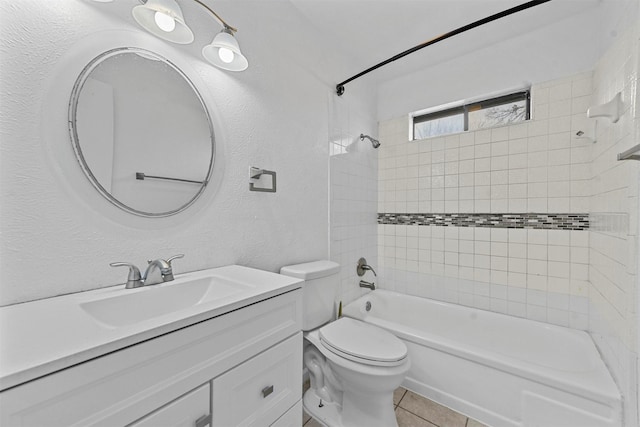 full bathroom with tile patterned flooring, vanity, tiled shower / bath combo, and toilet