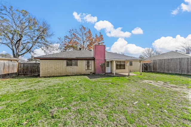 rear view of property with a yard and a patio