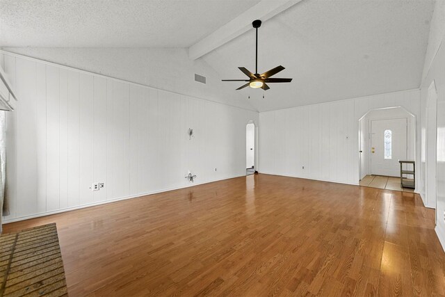 unfurnished living room featuring vaulted ceiling with beams, a textured ceiling, light hardwood / wood-style flooring, and ceiling fan