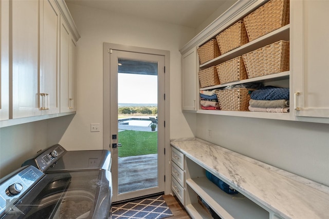 laundry area with washer and clothes dryer, dark hardwood / wood-style flooring, and cabinets