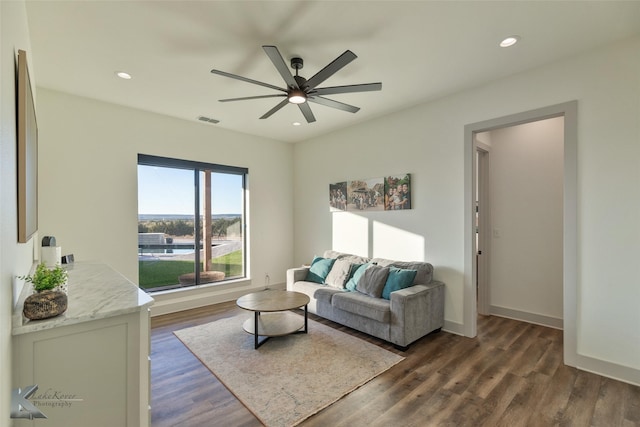 living room featuring ceiling fan and dark hardwood / wood-style flooring