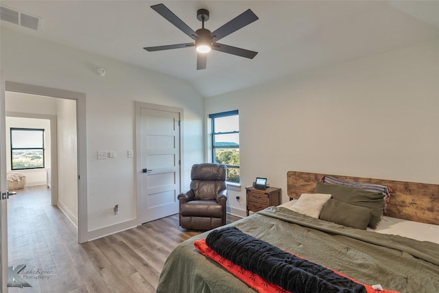 bedroom with ceiling fan, light wood-type flooring, and vaulted ceiling