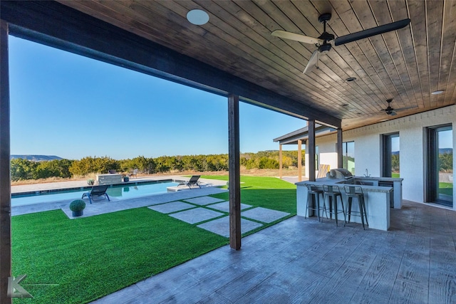 view of patio / terrace featuring a grill, ceiling fan, and exterior bar