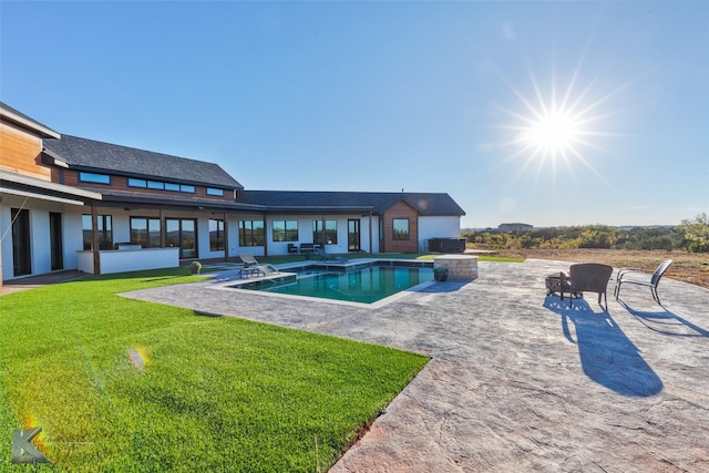 view of pool with a jacuzzi, a yard, and a patio