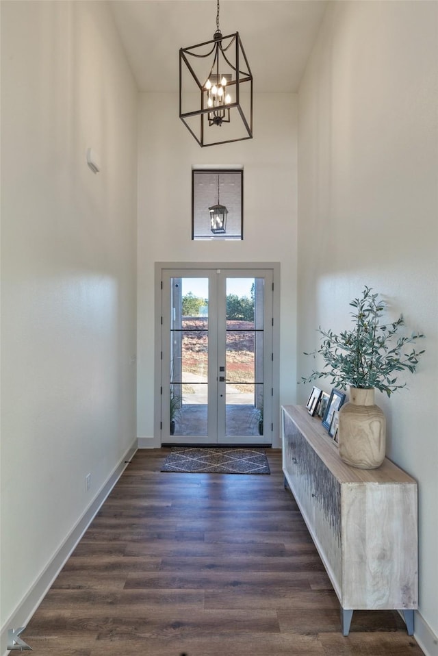 entryway featuring french doors, an inviting chandelier, and dark wood-type flooring