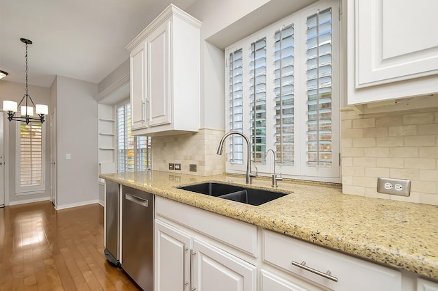 kitchen featuring hardwood / wood-style flooring, a sink, white cabinets, backsplash, and dishwasher